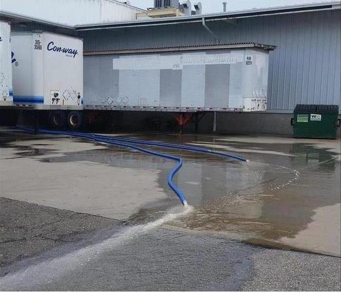 The hoses pictured are pumping the water out of the warehouse.